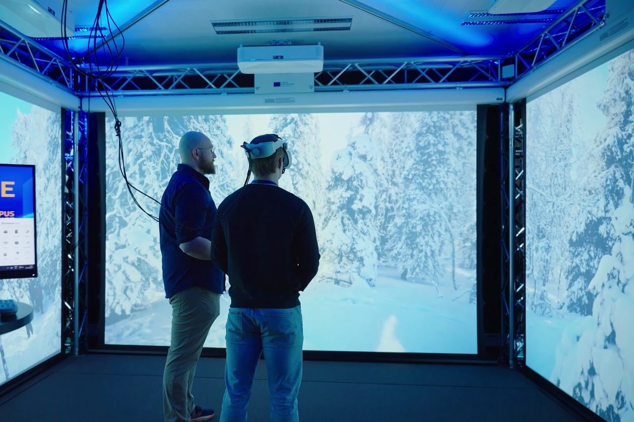 The Immersion Zone as a whole: a forest landscape projected onto three walls, with a truss frame and projectors above.